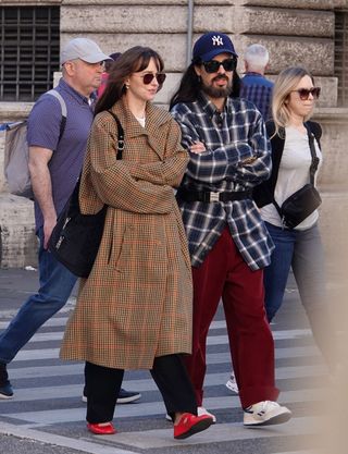 Dakota Johnson styles red flats with a houndstooth coat.