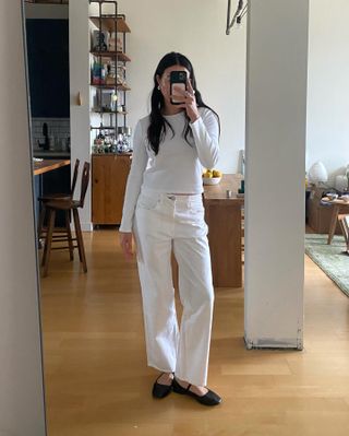 fashion influencer in an all-white outfit with classic black ballet flats